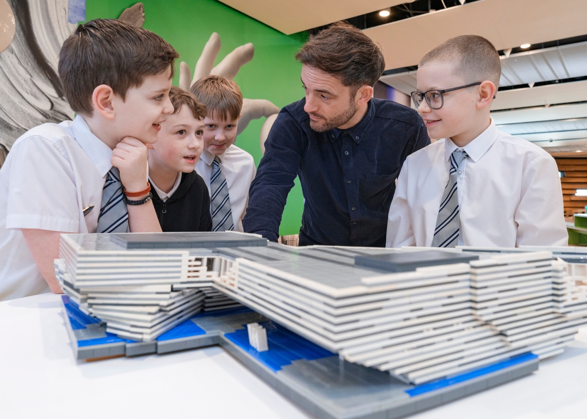 People standing behind a LEGO model of V&A Dundee
