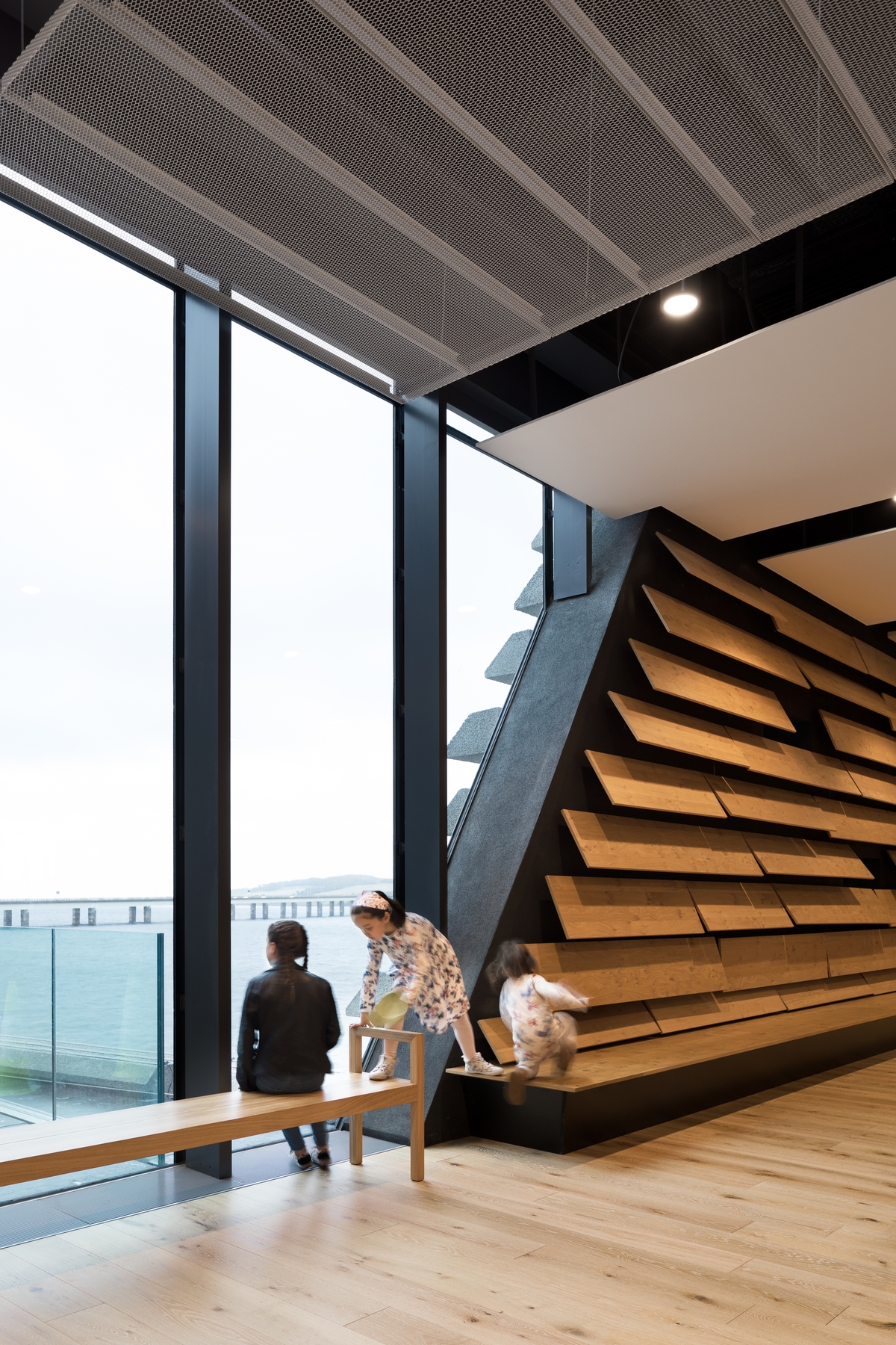 Children playing on a bench whilst looking out the window
